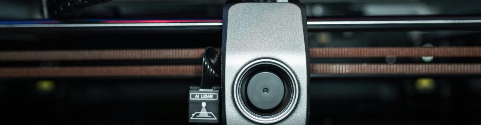 Detailed close-up of a 3D printer extrusion head in focus, showcasing modern technology.